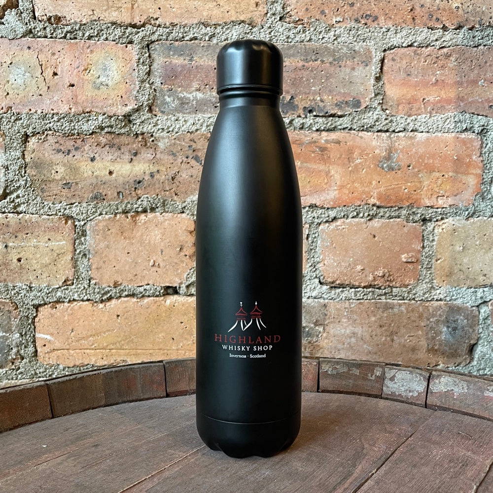 Black insulated bottle with a logo on a wooden surface and brick wall background