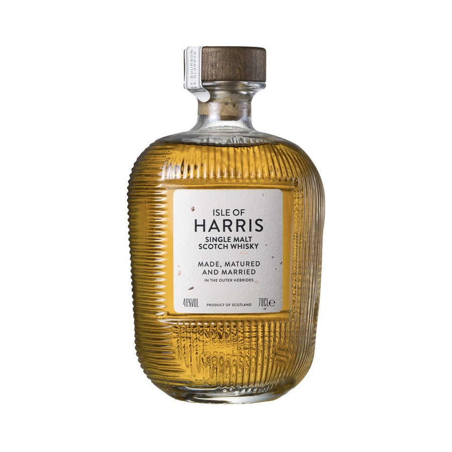 A bottle of Isle of Harris Single Malt Scotch Whisky with a ribbed clear glass body showing the golden amber liquid inside, a white label with black text, and a brown wooden stopper, set against a plain white background.